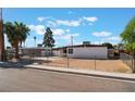 Charming single-story home with a gated yard, desert landscaping, and mature trees at 2825 Hickey Ave, North Las Vegas, NV 89030