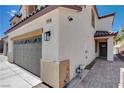 The side of this home shows a two-car garage, stucco siding and a tile roof at 3365 Moon Eclipse St, North Las Vegas, NV 89032
