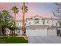 Charming two-story home with a three-car garage, lush landscaping, and a welcoming facade at 44 Tamarron Cliffs St, Las Vegas, NV 89148