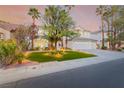 Beautiful home with manicured lawn, mature trees, landscape lighting, and a circular driveway at 44 Tamarron Cliffs St, Las Vegas, NV 89148
