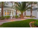 Inviting front yard featuring lush greenery, a decorative fountain, and a well-lit walkway at 44 Tamarron Cliffs St, Las Vegas, NV 89148