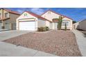 Single-story home featuring desert landscaping, a two-car garage, and a red tile roof at 6222 Eliza Ln, North Las Vegas, NV 89031