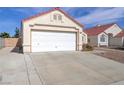 A two-car garage with a white door and a concrete driveway in front of the home at 6222 Eliza Ln, North Las Vegas, NV 89031