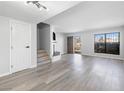 Open living room featuring gray hardwood floors, a modern fireplace, and an abundance of natural light at 6442 Ironbark Ln, Las Vegas, NV 89107