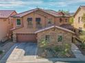 Charming home boasts a stone facade, tile roof, and well-maintained landscaping at 7125 Mountain Den Ave, Las Vegas, NV 89179