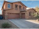 Three-car garage, stone accents, and desert-friendly landscaping create curb appeal at 7125 Mountain Den Ave, Las Vegas, NV 89179