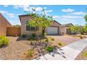 Inviting single-story home with desert landscaping and a brick paver driveway leading to a two-car garage at 715 Drammatico Pl, Henderson, NV 89011