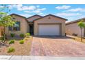 Beautiful one-story home showcasing desert landscaping and a brick paver driveway at 715 Drammatico Pl, Henderson, NV 89011