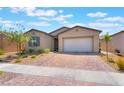 Attractive single-story home with desert landscaping, brick paver driveway, and an attached two-car garage at 715 Drammatico Pl, Henderson, NV 89011