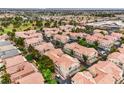 This aerial showcases a neighborhood with beautiful landscaping, lush trees, and warm terracotta roofs at 7450 S Eastern Ave # 2073, Las Vegas, NV 89123
