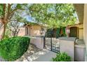 Inviting front entrance with an iron gate, lush greenery, and elegant exterior lighting at 7504 Via Sistina St, Las Vegas, NV 89131