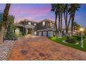 Stately two-story home featuring a large driveway, three-car garage, and mature palm trees at 7520 Captains Harbor Dr, Las Vegas, NV 89117