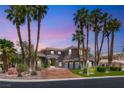 Elegant two-story home showcasing a well-manicured front yard, circular driveway and mature landscaping at 7520 Captains Harbor Dr, Las Vegas, NV 89117