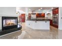 Modern kitchen with a fireplace, stainless steel appliances, an island, and plenty of cabinet space at 7526 Gossamer Wind St, Las Vegas, NV 89139