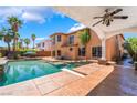 Gorgeous pool and backyard, complete with palm trees, a diving board, and patio at 7526 Gossamer Wind St, Las Vegas, NV 89139