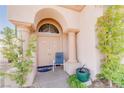 Inviting entryway with columns, an arched doorway, and lush greenery at 7815 Windward Rd, Las Vegas, NV 89147