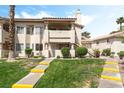 Inviting condo exterior with lush green lawn, mature trees and warm stucco finish at 7932 Diamond Rock Way # 101, Las Vegas, NV 89128
