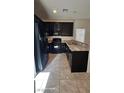 Well-equipped kitchen with dark cabinetry, stainless steel appliances, and a granite countertop bar at 8928 Hand Painted Ct, Las Vegas, NV 89149