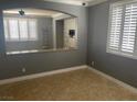 Open-concept living room featuring tile floors, plantation shutters, and neutral paint at 9232 Marlia St, Las Vegas, NV 89123