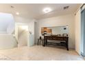 Bright living room with tile flooring, view of kitchen, and stairway to the upper level at 9986 Sand Key St, Las Vegas, NV 89178