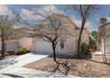 Two-story home featuring a red tile roof, white stucco, concrete driveway and low maintenance desert landscaping at 10075 Yellow Canary Ave, Las Vegas, NV 89117