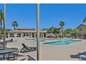 Community pool area with lounge chairs and palm trees in a sunny outdoor setting at 1121 Via Castelli, Henderson, NV 89052