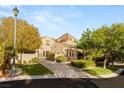 Elegant two-story home with lush landscaping, a private gated entrance, and mature trees at 1200 Dry Point Ct, Las Vegas, NV 89144