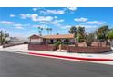 Charming single-story home with a well-maintained lawn, and palm trees, perfect curb appeal at 1534 Irene Dr, Boulder City, NV 89005