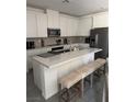 Well-lit kitchen features an island with seating and stainless steel appliances at 219 Vanhoy Ave, Henderson, NV 89011
