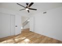 Bright bedroom with wood floors, modern ceiling fan and access to stairs through double doors, creating a spacious and airy feel at 2405 Pickwick Dr # 55, Henderson, NV 89014