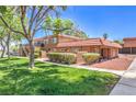 Charming two-story condo featuring a red tile roof, well-maintained landscaping and a lush green lawn at 250 Shadybrook Ln # D, Las Vegas, NV 89107