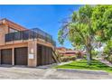 Two-story building with private garages and outdoor staircase, set amongst lush green lawns at 250 Shadybrook Ln # D, Las Vegas, NV 89107