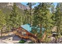 Aerial view showcasing the home's design, lush landscaping, and mountain scenery at 274 Ski Trail Rd, Mount Charleston, NV 89124
