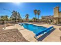 Sparkling swimming pool with a safety cover, set in a well-maintained backyard with mature landscaping at 3708 Calumet Farm Cir, North Las Vegas, NV 89031