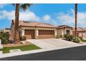 Beautiful home with a three-car garage, desert landscaping, and a tile roof, complemented by palm trees at 4128 Tarkin Ave, Las Vegas, NV 89120
