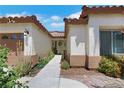 Welcoming walkway to the front door with desert landscaping and a view of the three-car garage at 4128 Tarkin Ave, Las Vegas, NV 89120
