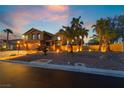 Beautiful two-story home with a well-maintained front yard and lit landscaping, with several palm trees at 4200 Scott Peak Ct, Las Vegas, NV 89129