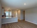 Open-concept living room featuring wood flooring, recessed lighting, and a kitchen island with a sink at 4409 Pioche Ave, North Las Vegas, NV 89032