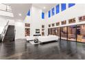 Bright living room with soaring ceilings, modern fireplace, dark wood flooring, and access to the backyard at 5429 Succulent Rose Dr, Las Vegas, NV 89135