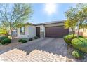 Charming single-story home showcasing a well-manicured lawn and a two-car garage, complete with stone accents and desert landscaping at 5633 Alitak Bay St, North Las Vegas, NV 89081