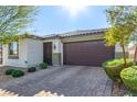 Charming single-story home showcasing a well-manicured lawn and a two-car garage, complete with stone accents and desert landscaping at 5633 Alitak Bay St, North Las Vegas, NV 89081