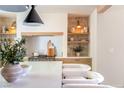 Well-lit kitchen features stone accents, an oven range, wooden shelves and drawers, and bar seating at 5741 S Pearl St, Las Vegas, NV 89120