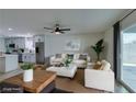 Comfortable living room with white sofa, ottoman, ceiling fan, and sliding glass door to the backyard at 5800 Balzar Ave, Las Vegas, NV 89108