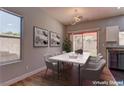 Dining room with modern light fixture, table with six chairs, large window, and sliding door to yard at 6236 Tierra Cove St, North Las Vegas, NV 89081