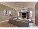 Staged living room with modern furniture, neutral tones, sleek ceiling fan and a stylish fireplace at 6236 Tierra Cove St, North Las Vegas, NV 89081