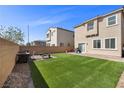 Serene backyard with lush artificial grass, creating a perfect outdoor living space for relaxation and entertainment at 6626 Evander St, North Las Vegas, NV 89086
