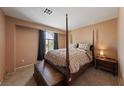 Bedroom featuring a four-poster bed, plush bedding, natural light, and a cozy ambiance at 675 Harbor Mist Ave, Henderson, NV 89015