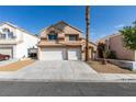 Two-story home featuring a three-car garage, desert landscaping, and a tile roof at 71 Sea Holly Way, Henderson, NV 89074