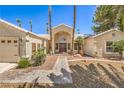 Inviting single-story home with an arched entry and a well-maintained front yard with desert landscaping at 7300 Breezy Night Ct, Las Vegas, NV 89129