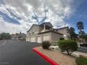 Exterior of multi-story condo building with attached garages, red rock landscaping, and mature palm trees at 75 N Valle Verde Dr # 625, Henderson, NV 89074